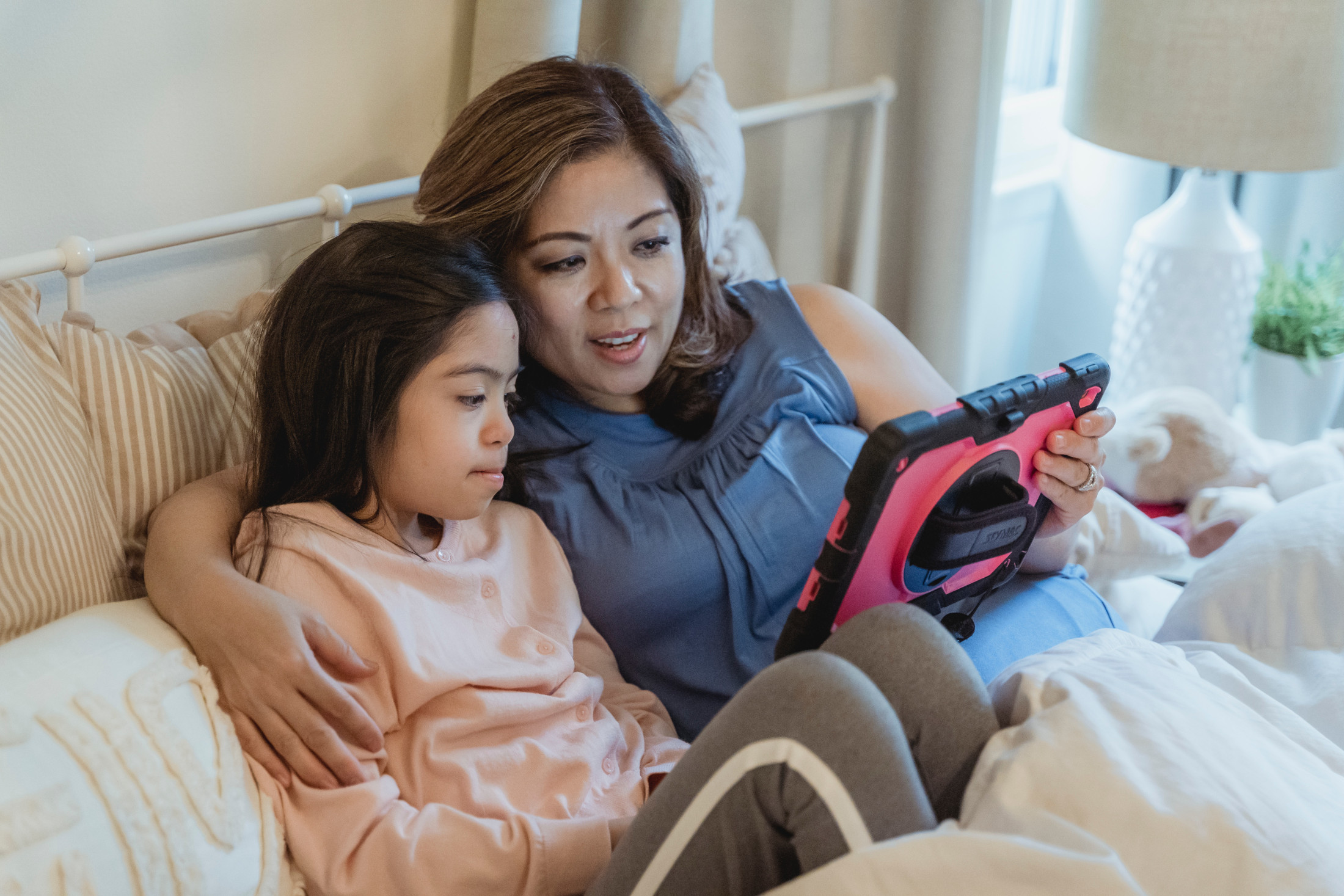 Mother and daughter work with a therapist during a telehealth visit.